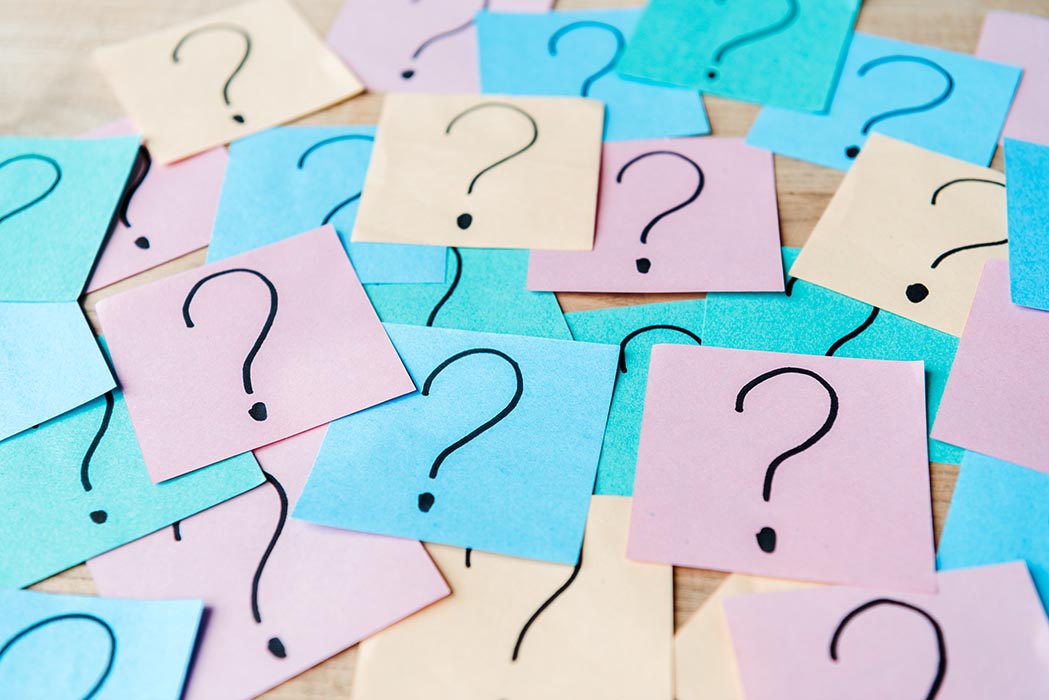 A selection of colorful sticky notes with question marks drawn on them